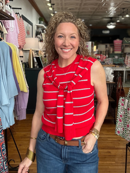 Woman wearing a red striped top and blue jeans in a clothing store.