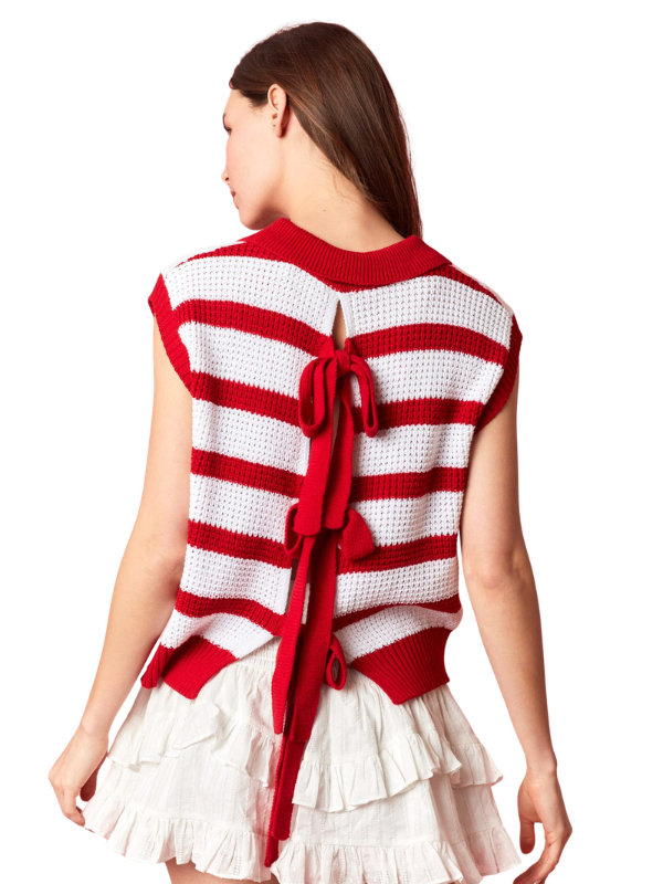 Woman wearing a red and white striped sweater with a bow detail on a white background