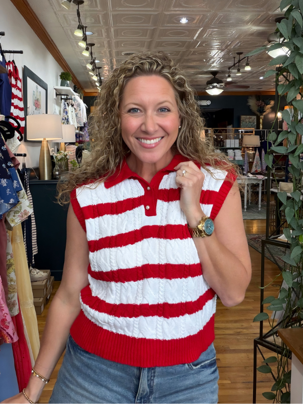 Woman wearing a red and white striped sleeveless sweater in a store setting