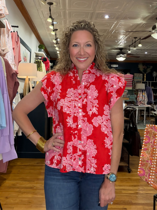 Woman wearing a red floral blouse in a clothing store