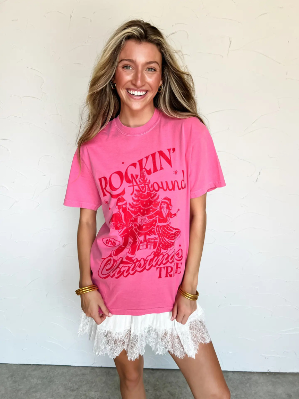 Woman wearing a pink t-shirt with red text and graphics against a white background