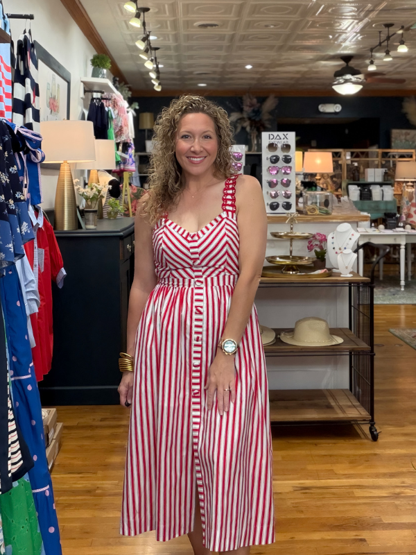 Woman in a red and white striped dress standing in a store.
