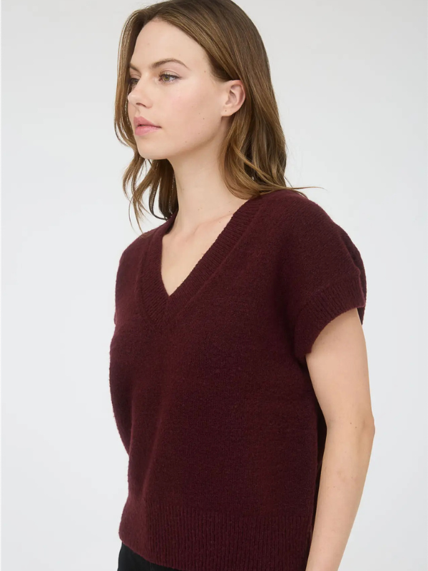 Woman wearing a burgundy sweater against a white background