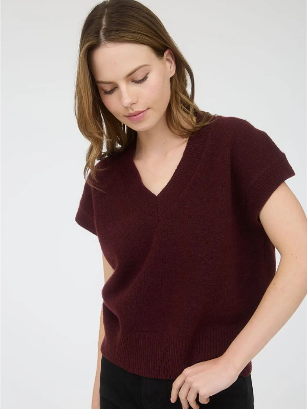 Woman wearing a burgundy sweater against a white background