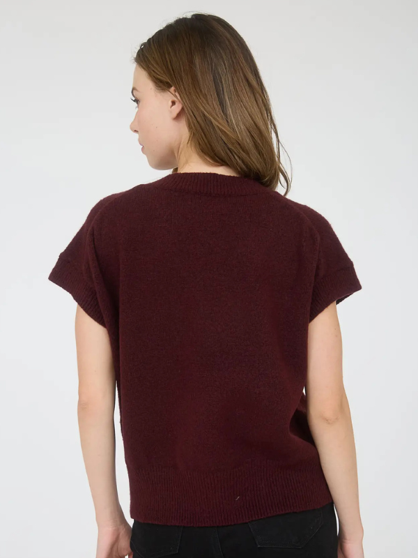 Woman wearing a burgundy sweater against a white background