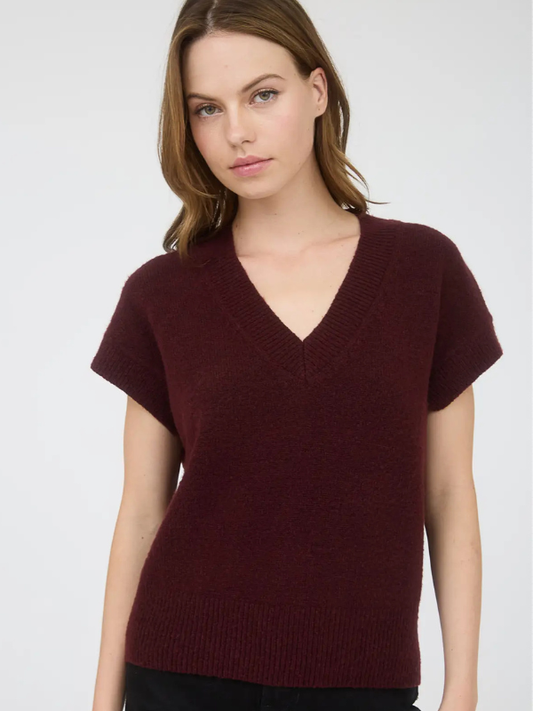 Woman wearing a burgundy sweater against a plain background