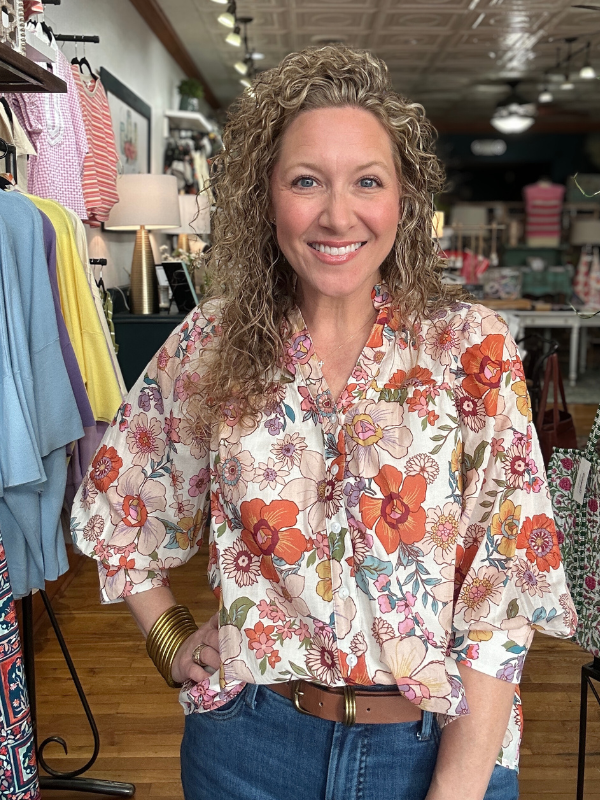 Woman wearing a floral blouse in a clothing store