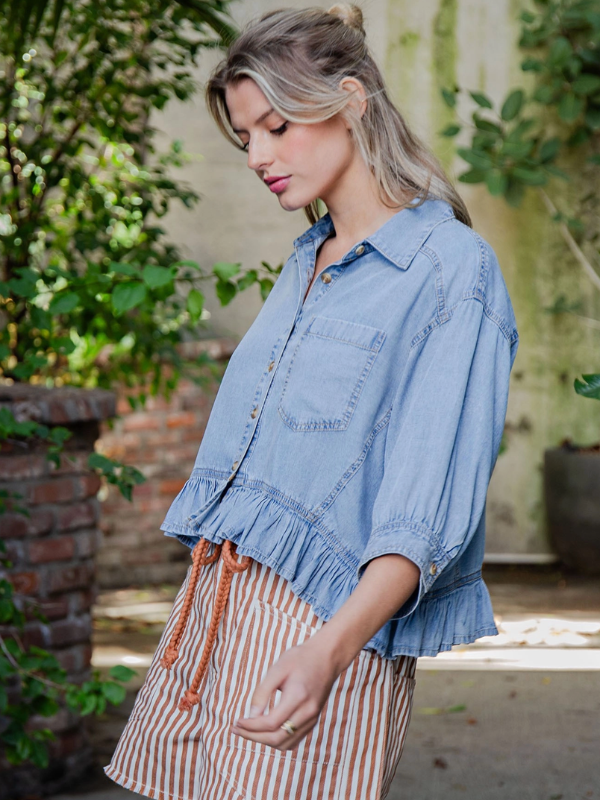Woman wearing a denim shirt and striped skirt outdoors