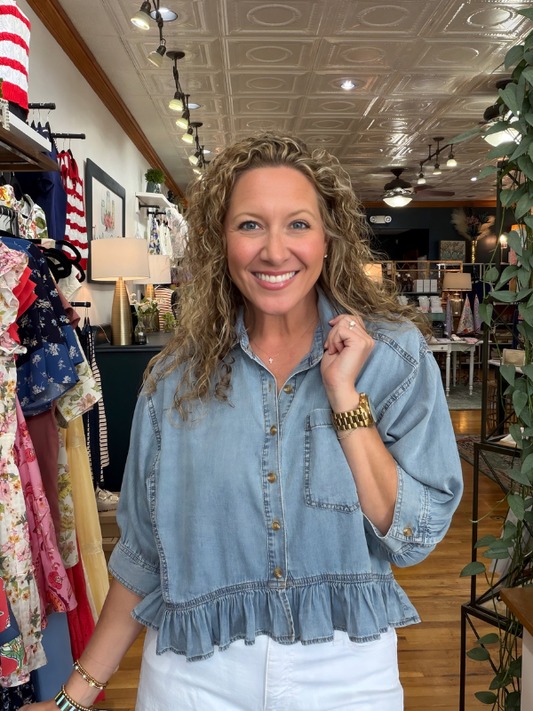 Woman wearing a denim jacket in a store setting