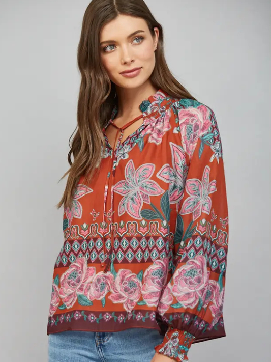 woman wearing a rust fall floral blouse and jeans