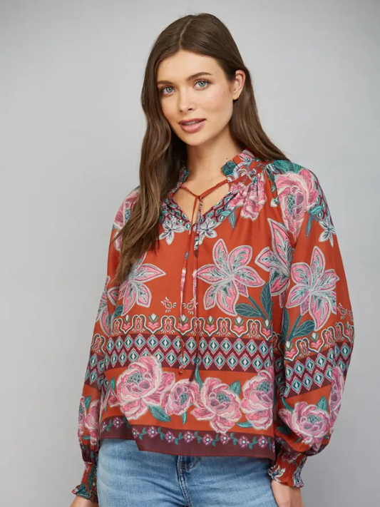 woman wearing a rust fall floral blouse and jeans
