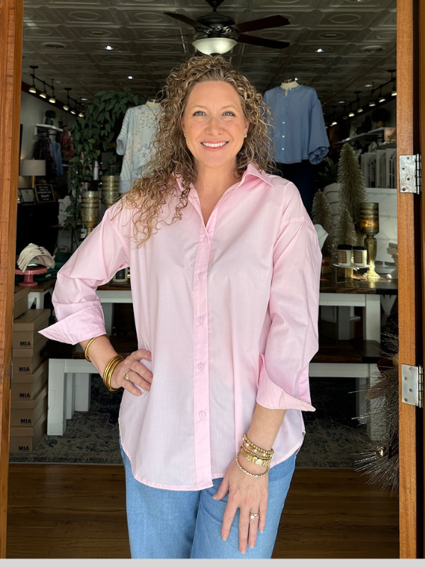 Woman wearing a pink shirt in a store setting