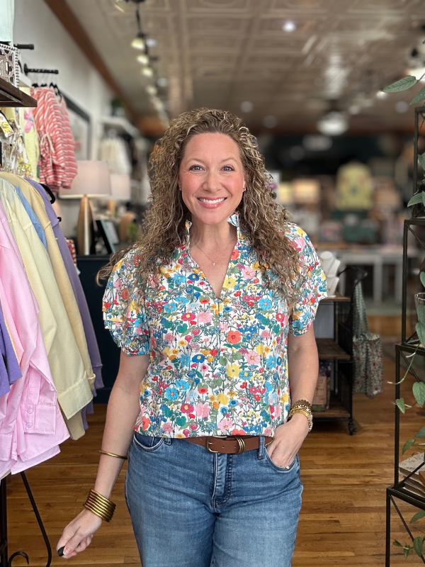 Woman wearing a colorful floral blouse in a clothing store