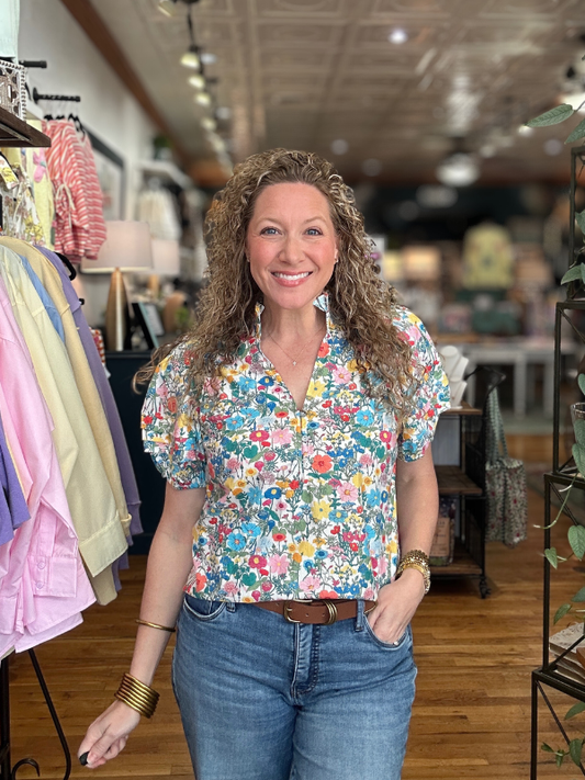 Woman wearing a colorful floral blouse in a clothing store