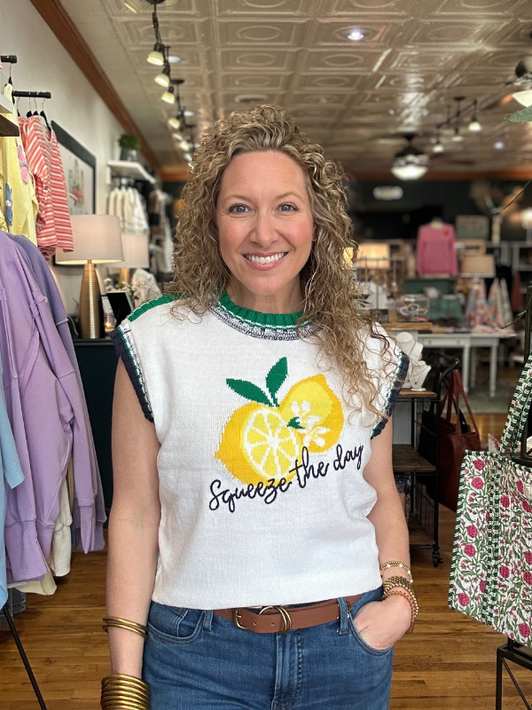 Woman wearing a white t-shirt with a lemon graphic and text in a store setting