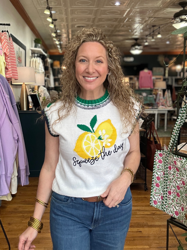 Woman wearing a white t-shirt with a lemon graphic and text in a store setting