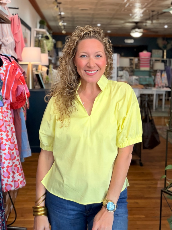 Woman wearing a bright yellow shirt in a store setting