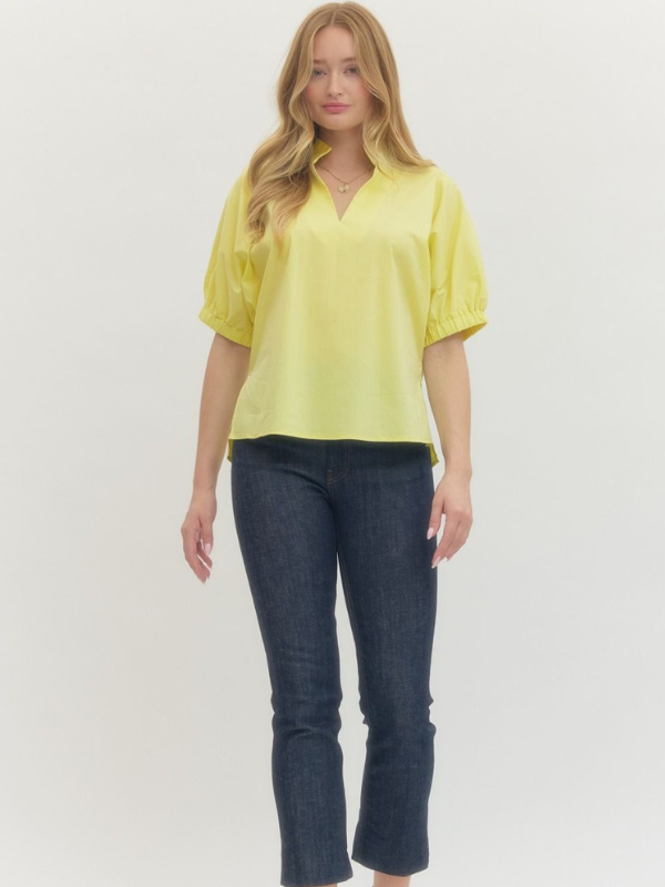 Woman wearing a yellow blouse and blue jeans on a white background