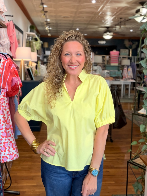 Woman wearing a bright yellow blouse in a store setting