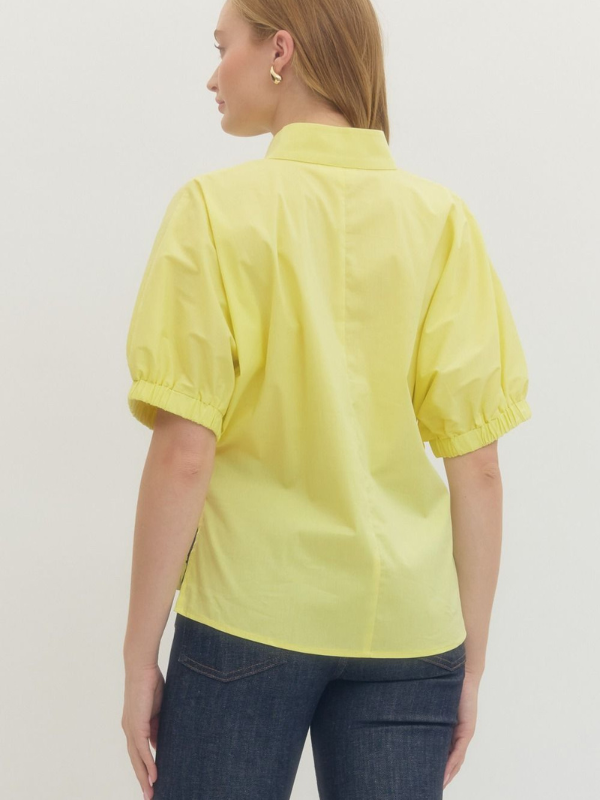 Person wearing a yellow shirt and blue jeans on a plain background