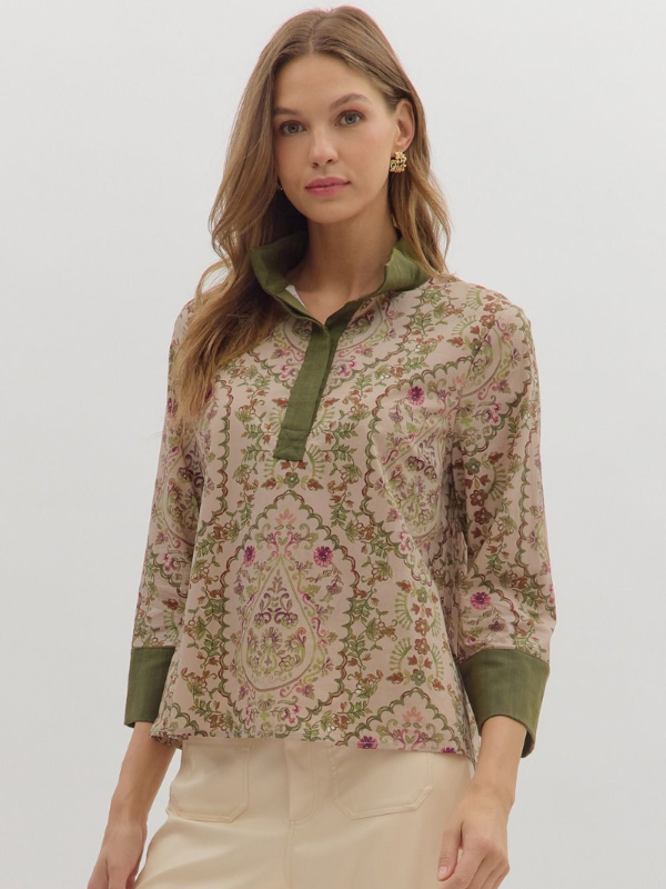 Woman wearing a floral blouse with green accents on a white background