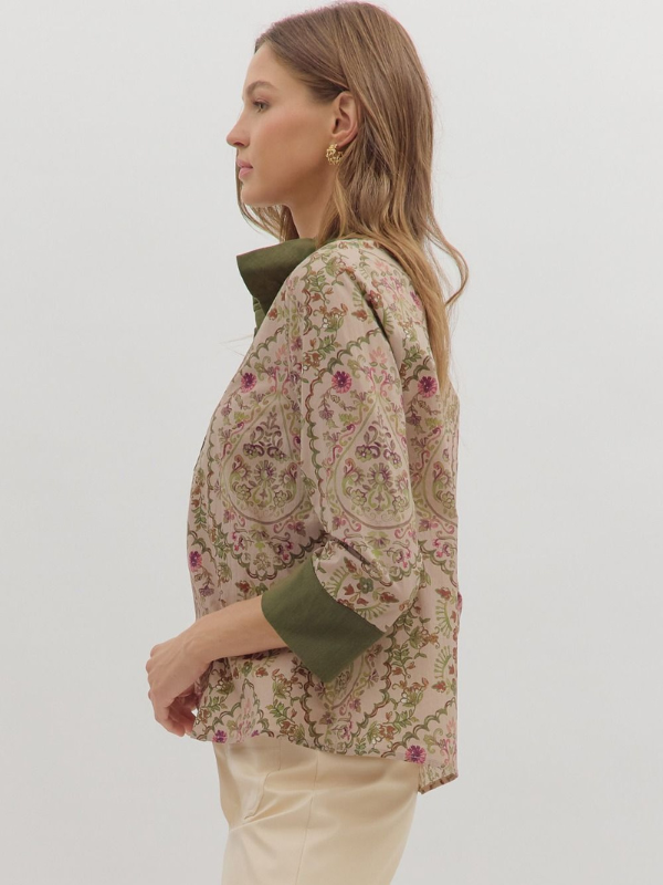 Woman wearing a floral jacket with green accents on a white background