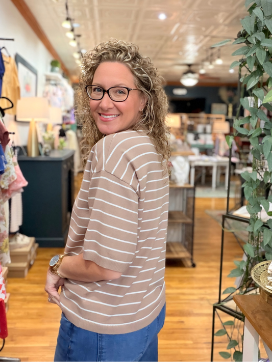 Woman wearing a striped sweater in a store setting