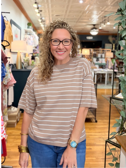 Woman wearing a striped shirt and glasses in a store setting