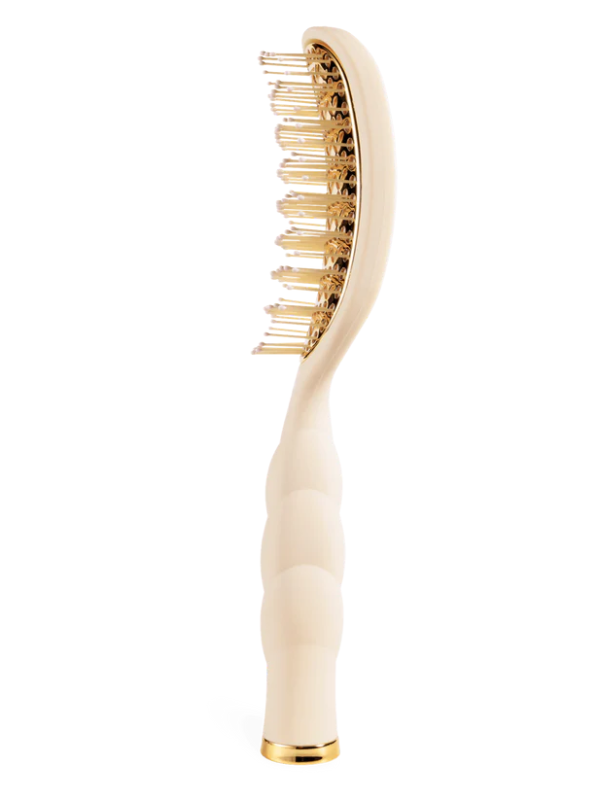 Beige hairbrush with gold bristles on a white background