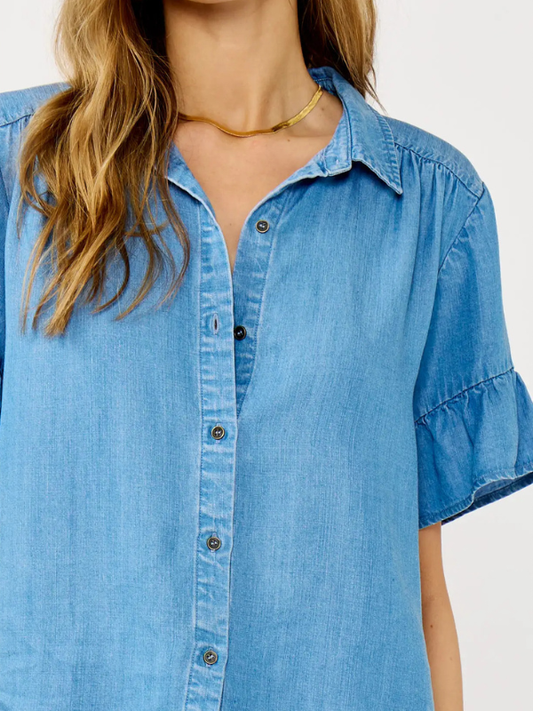 Blue denim shirt worn by a person on a white background