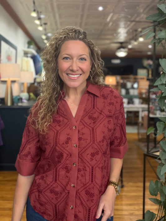 woman wearing a terra cotta button up collared top 