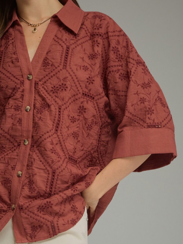 woman wearing a terra cotta button up collared top 