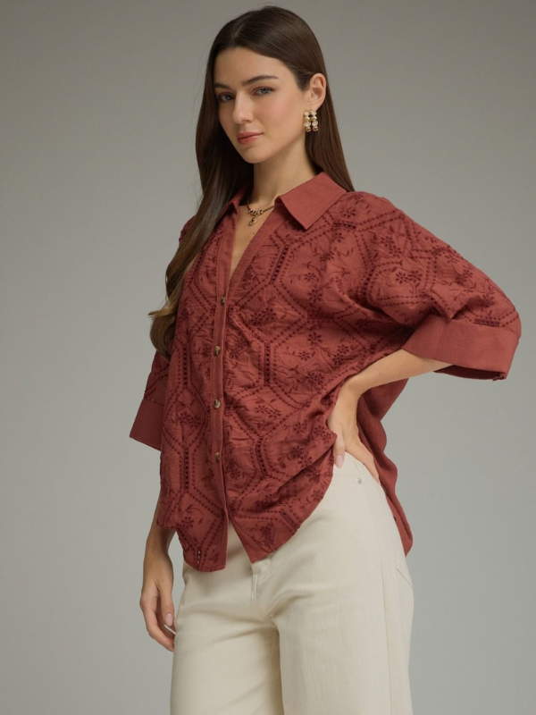 woman wearing a terra cotta button up collared top 
