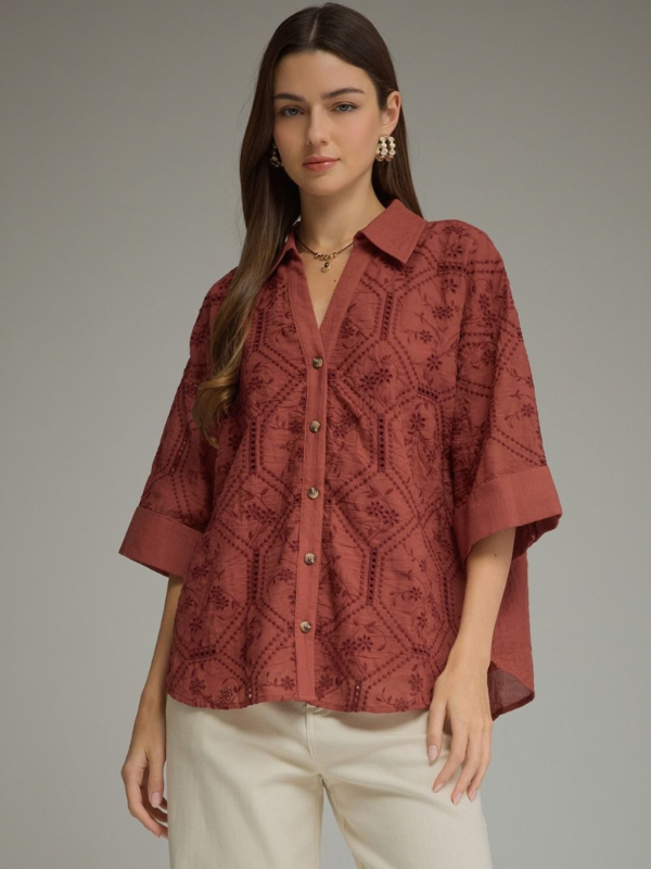 woman wearing a terra cotta button up collared top 