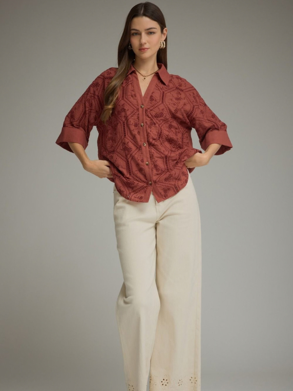 woman wearing a terra cotta button up collared top 