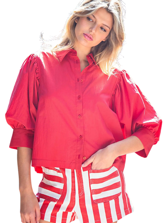 woman wearing a red top and striped shorts 