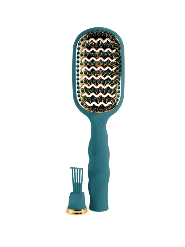 A teal and gold paddle hairbrush with a textured handle, shown alongside its matching stand and small gold-accented accessory on a plain white background.