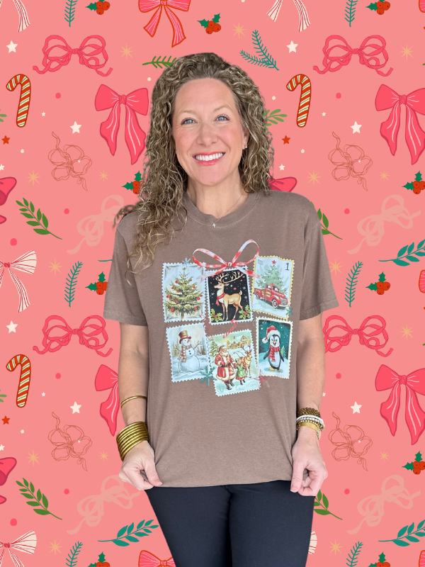 Woman wearing a brown t-shirt with festive design on a pink background with Christmas elements