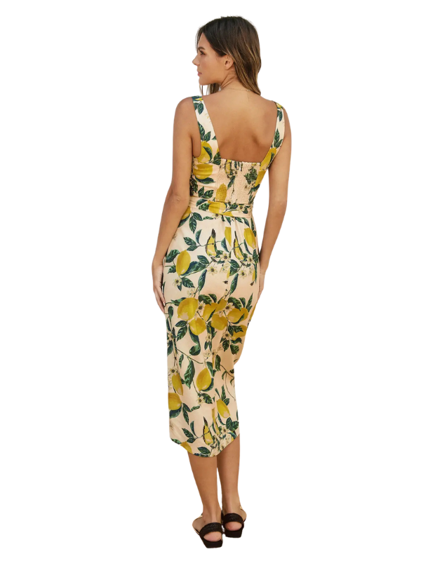Woman wearing a floral dress with lemon pattern on a white background