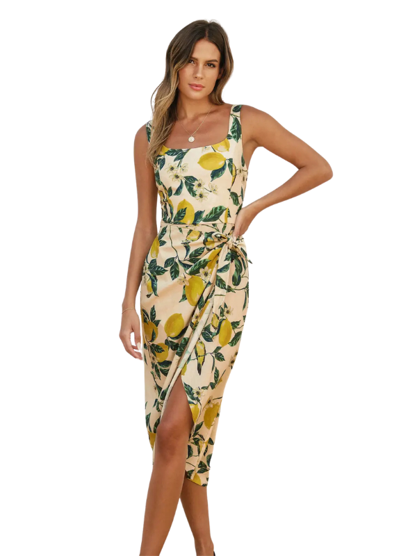 Woman wearing a sleeveless dress with lemon print on a white background