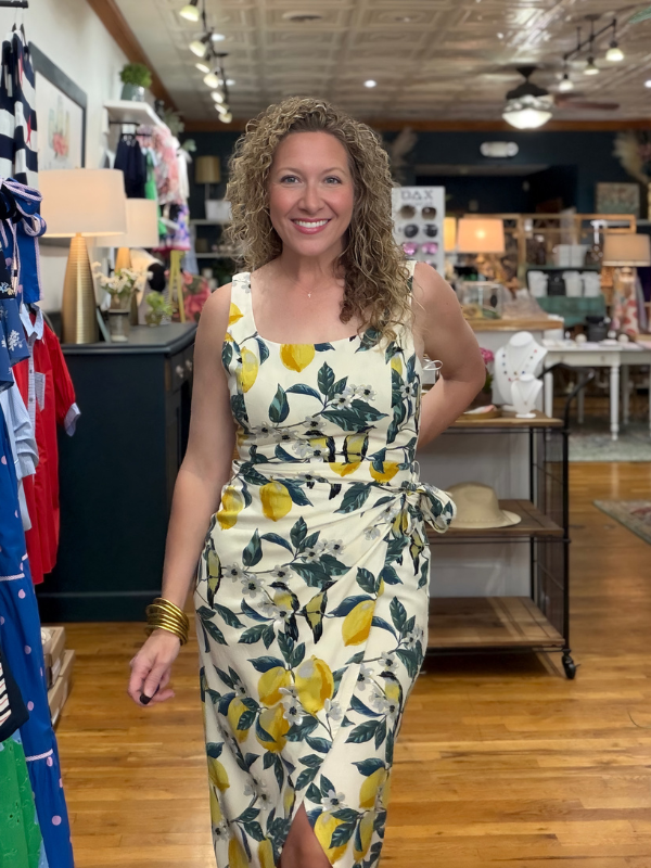 Woman wearing a lemon-patterned dress in a store setting