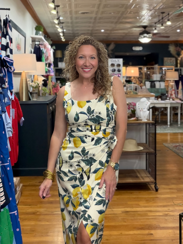 Woman wearing a floral dress with lemons in a store setting
