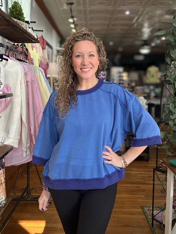 Woman wearing a blue sweater in a store setting