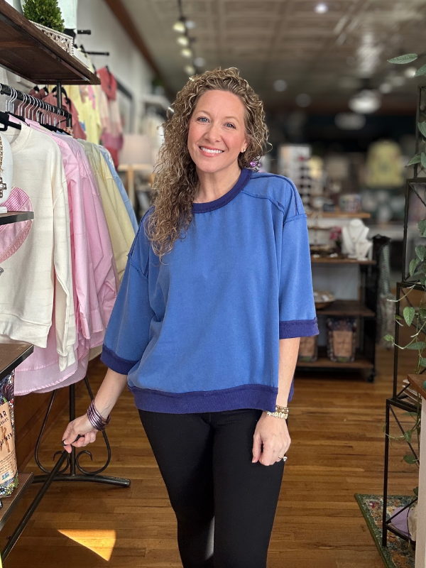 Woman wearing a blue sweater in a store setting