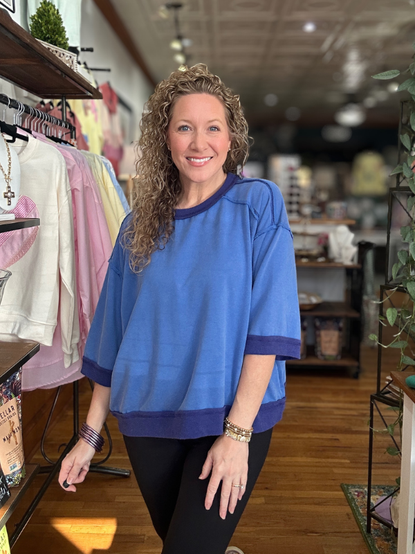 Woman wearing a blue shirt in a store setting