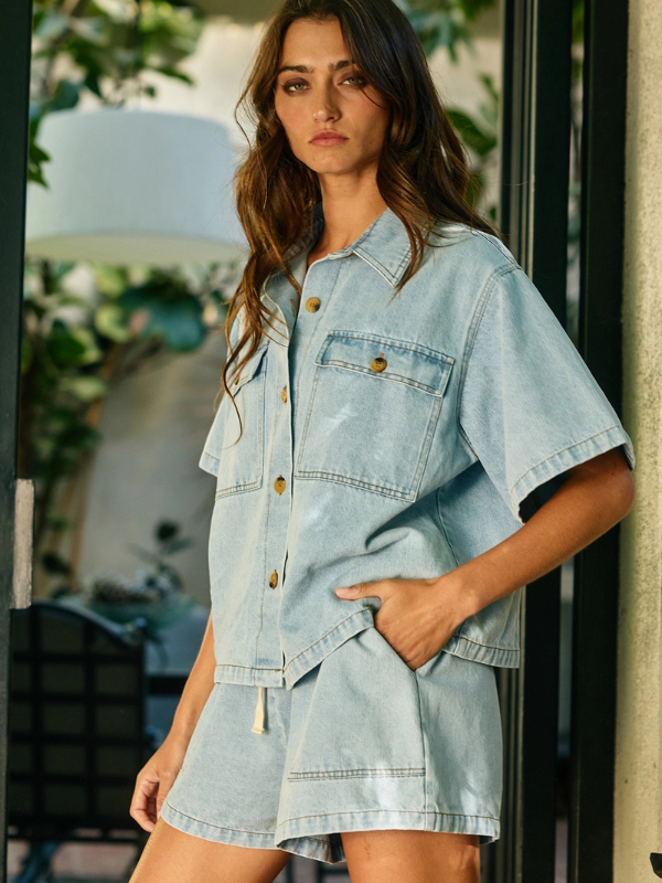 Woman wearing a light blue denim dress standing outdoors.