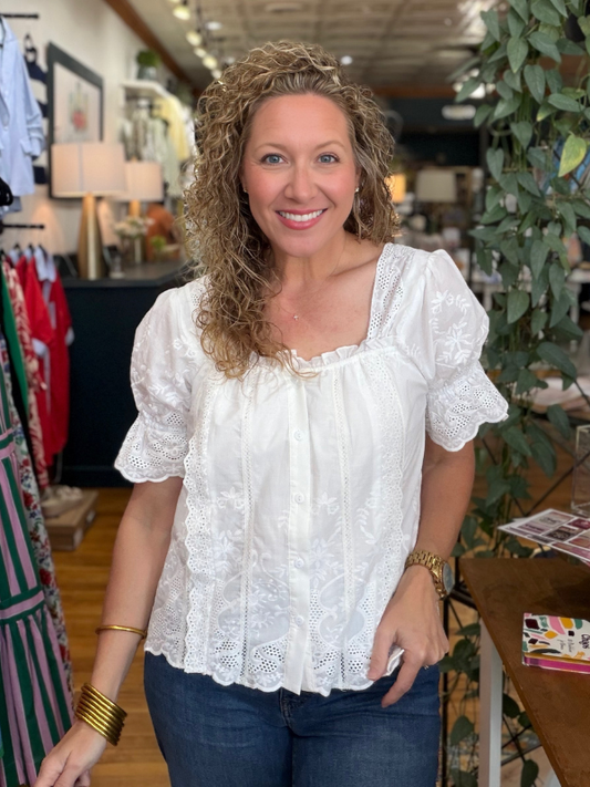 Woman wearing a white blouse in a store setting