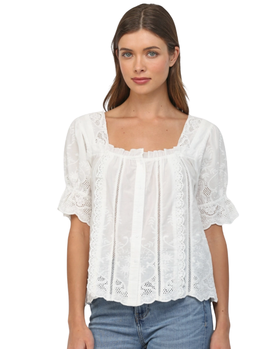 Woman wearing a white lace blouse with blue jeans on a white background
