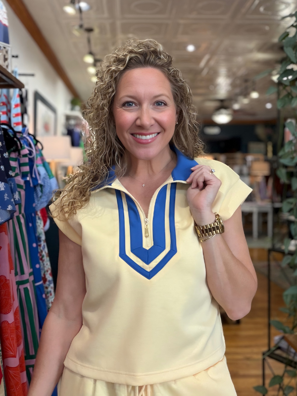 Woman wearing a yellow outfit with blue accents in a store setting