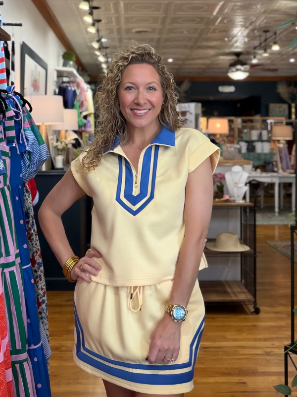 Woman wearing a yellow dress with blue accents in a store setting